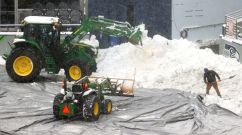 Field staff work on clearing the snow at Lumen Field